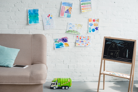 close up view of empty childish room with sofa, blackboard and toy truck on floorの写真素材
