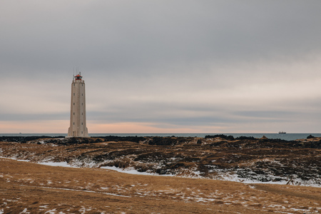lighthouse at seacoast and cloudy sky in icelandの写真素材