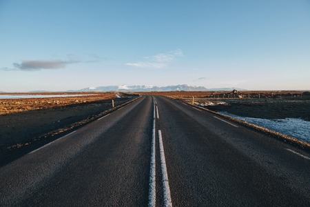 empty asphalt road and beautiful mountains on horizon in icelandの写真素材