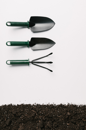 top view of arranged gardening tools and ground isolated on whiteの写真素材
