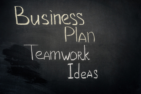 Business plan and teamwork ideas inscription on black chalkboardの写真素材