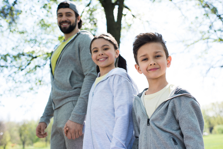 smiling children with father in parkの写真素材