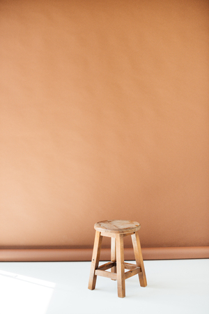 Empty wooden stool on brown backgroundの写真素材