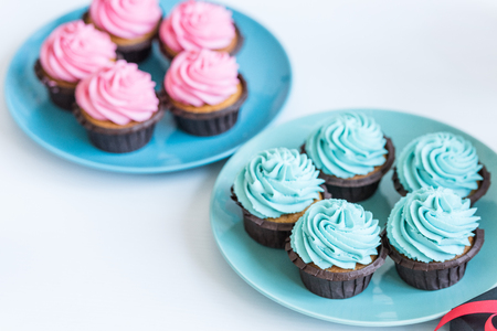 pink and blue cupcakes on plates on white table, baby shower party conceptの写真素材