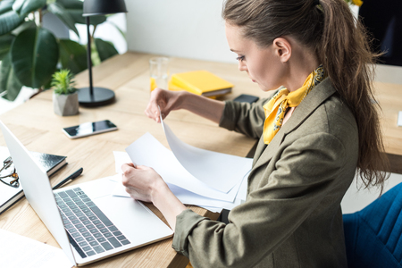 high angle view of businesswoman working with papers in officeの写真素材