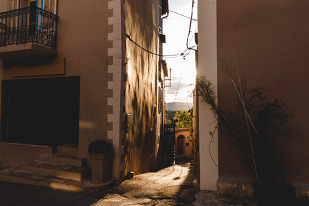 narrow street with ancient buildings at old town with evening sky on background, Cannes, Franceの写真素材
