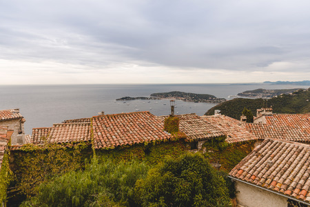 rooftops of houses on hill over seashore, Eze, France