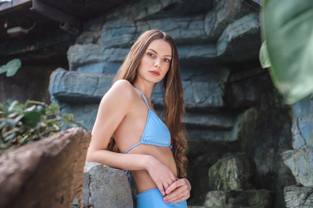 beautiful young woman posing in blue bikini on tropical resortの写真素材