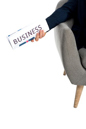 cropped shot of businessman sitting in armchair and holding newspaper isolated on whiteの写真素材