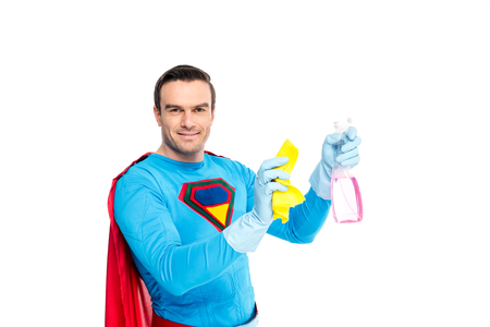 handsome smiling  holding rag and spray bottle with detergent isolated on whiteの写真素材