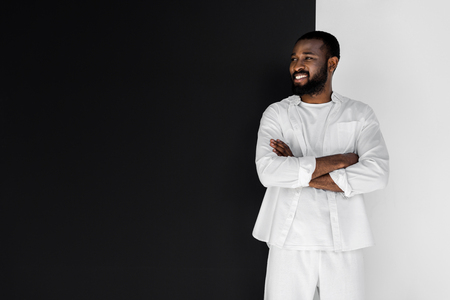 smiling stylish african american man standing with crossed arms and looking awayの写真素材