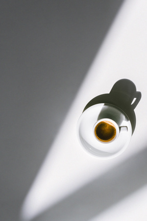 top view of cup of tasty coffee in white cup on white surfaceの写真素材