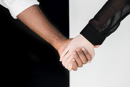 cropped image of multicultural couple holding hands, yin yang conceptの写真素材