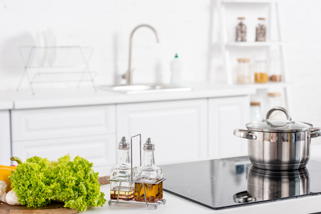 fresh ingredientes and electric stove with saucepan on kitchenの写真素材