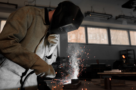 manufacture worker welding metal with sparks at factoryの写真素材