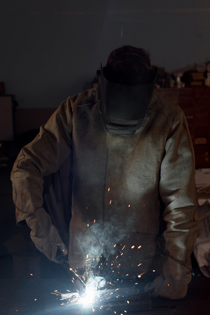 manufacture worker welding metal with sparks at factoryの写真素材
