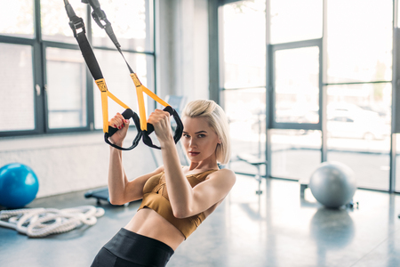portrait of young caucasian sportswoman training with resistance bands at gymの写真素材