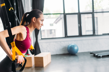side view of asian female athlete training with resistance bands at gymの写真素材