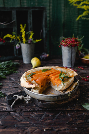 amazing pastry with carrots and herbs on wooden tableの写真素材