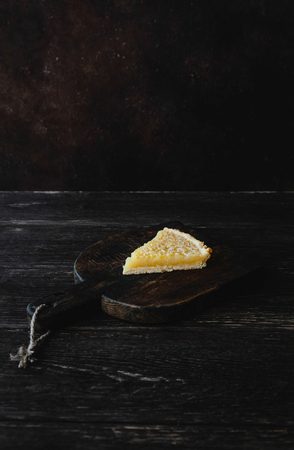 piece of tasty lemon pie on wooden cutting boardの写真素材