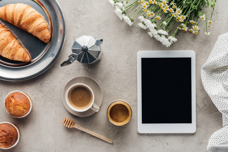 top view of coffee with pastry and tablet with blank screen on concrete surfaceの写真素材