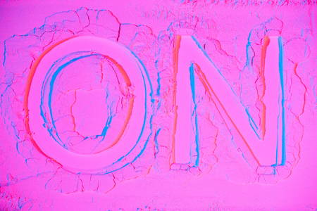 top view of on sign on pink neon powder texture