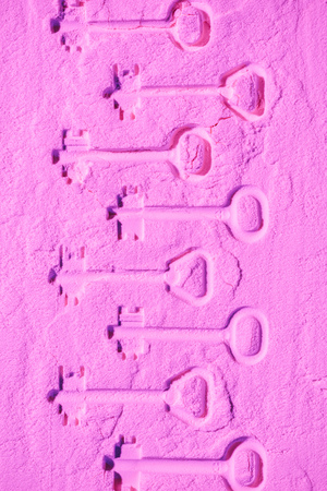 shapes of keys on pink colored powder textureの写真素材