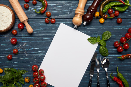top view of blank menu template, fresh vegetables, cutlery and spices on wooden surfaceの写真素材