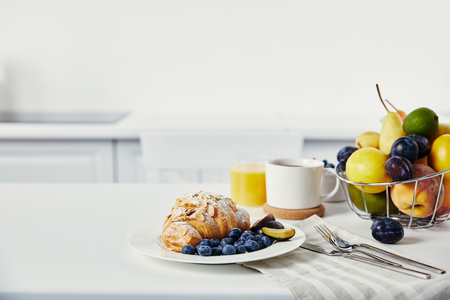 close up view of tasty breakfast with croissant and cup of coffee on white surfaceの写真素材