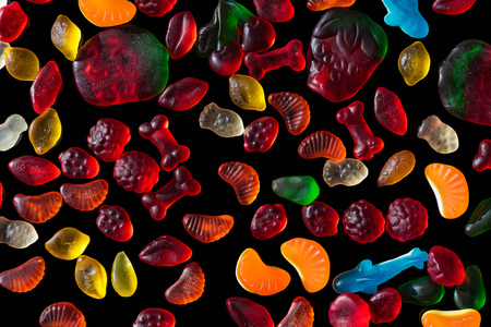top view of different colored jelly candies isolated on blackの写真素材