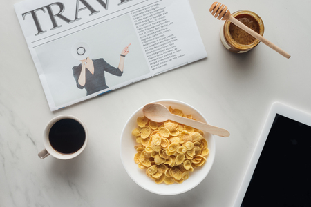 top view of breakfast of cereal and coffee on white marble surface with newspaper and tableの写真素材