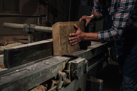 cropped shot of carpenter working with wood at workshopの写真素材