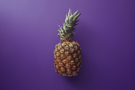 top view of pineapple on violet surfaceの写真素材