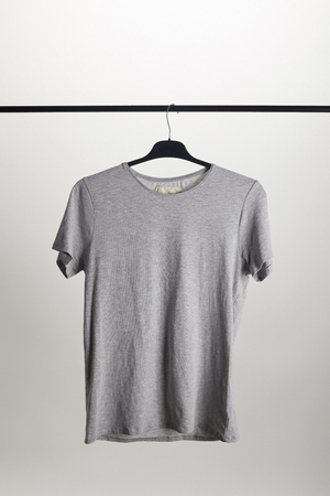 one grey shirt on hanger isolated on whiteの写真素材