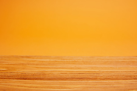 empty wooden surface and bright orange backgroundの写真素材