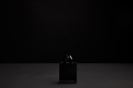 close up view of black paper shopping bag on black backgroundの写真素材