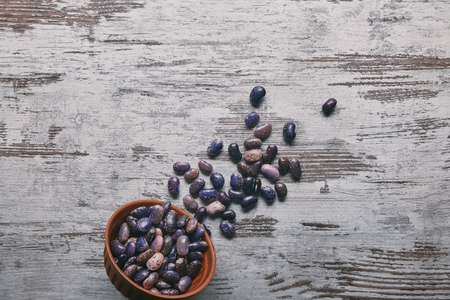 Dry haricot beans in bowl on rustic wooden table