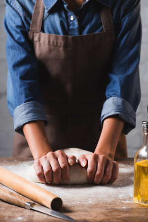 partial view of woman kneading dough for pizzaの写真素材