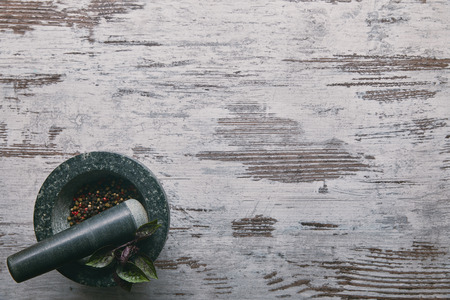 Mortar and pestle with pepper on rustic wooden tableの写真素材