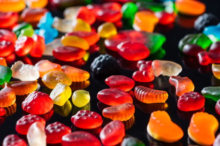 different colored jelly candies on black surfaceの写真素材