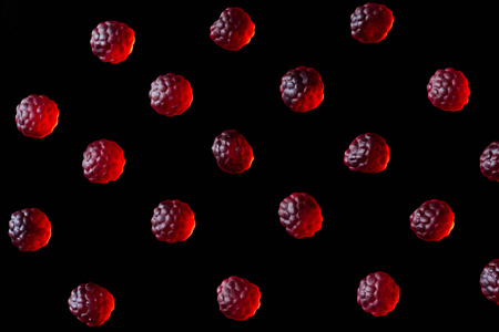 collection of red jelly candies in shape of raspberries isolated on blackの写真素材