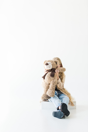 adorable little child hugging teddy bear isolated on whiteの写真素材