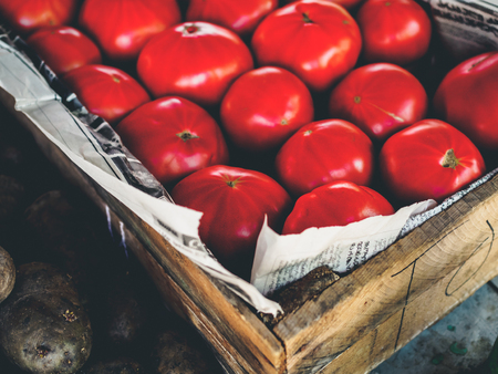 close up of ripe red tomatoes in wooden box at georgian market