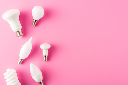 top view of various types of light bulbs on pink background