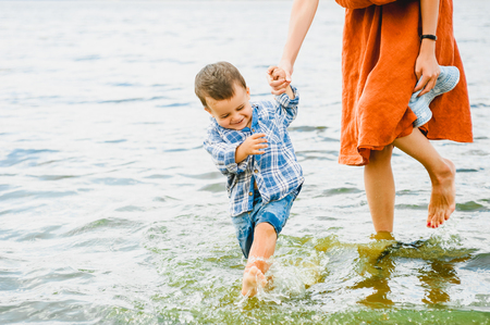 cropped image of mother and son having fun in river in summerの写真素材
