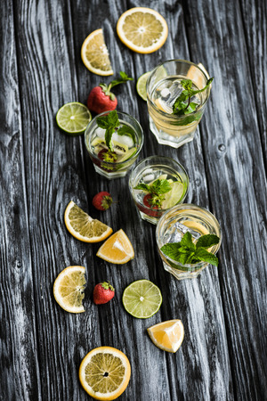 top view of fresh cold summer cocktails in glasses on wooden tableの写真素材