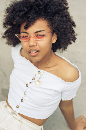 high angle view of beautiful young african american woman in sunglasses looking at cameraの写真素材