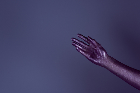 partial view of tender hand in ultra violet glitter, isolated on purpleの写真素材