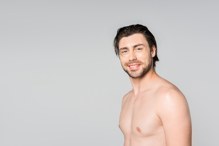 portrait of handsome shirtless man with stylish hairstyle isolated on greyの写真素材