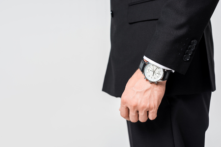 cropped shot of businessman in black suit with watch on wrist isolated on greyの写真素材
